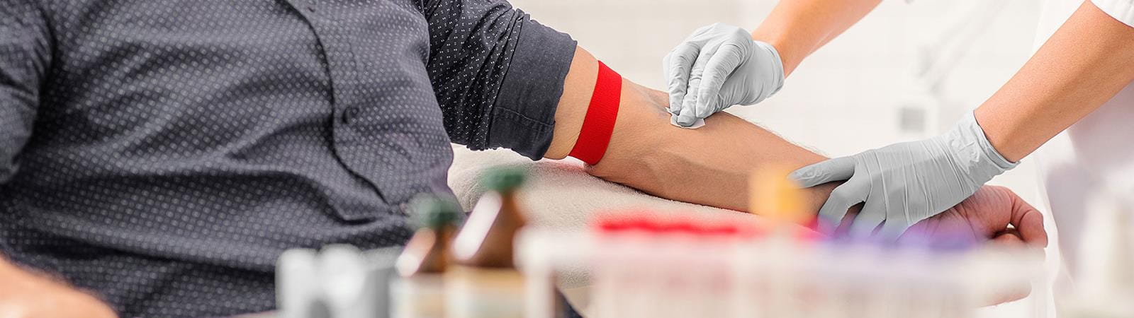 Nurse swabbing male patient arm for a blood test